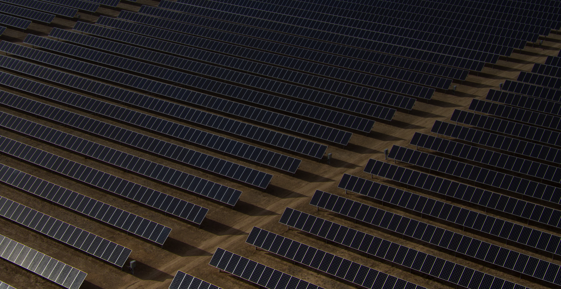 Imagen de fondo donde se aprecia una gran planta solar en el desierto.